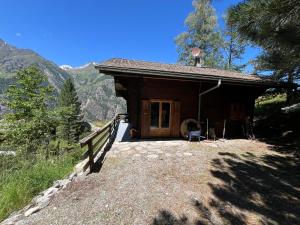 a small cabin in the mountains with a fence at Chalet Karin in Sankt Niklaus