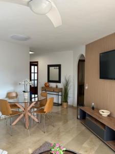 un salon avec une table, des chaises et une télévision dans l'établissement Brisas playa y Golf, à Malaga