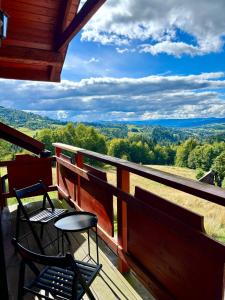 a balcony with two chairs and a table and a view at Apartamenty Kowolówka Koniaków in Koniaków
