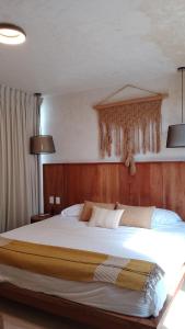 a bedroom with a large bed with a wooden headboard at Studio in La Veleta with private rooftop in Tulum