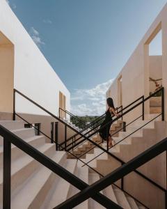 a woman walking down stairs in a building at Studio in La Veleta with private rooftop in Tulum +5 photos