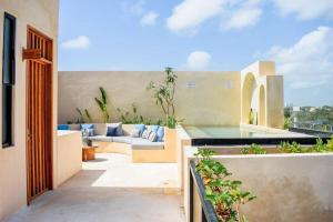 an outdoor patio with a couch on a building at Studio in La Veleta with private rooftop in Tulum