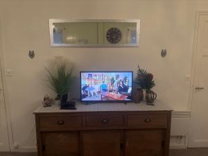 a tv sitting on top of a dresser in a room at appartement de letty in Fort-Mahon-Plage