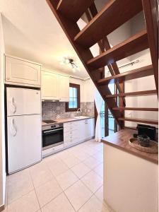 a kitchen with white appliances and a wooden ceiling at Restia House in Steni Vala Alonissos