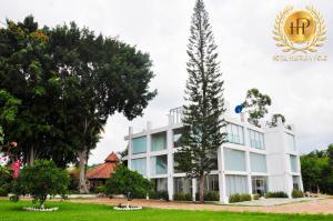 un edificio con un árbol delante de él en Hotel Herrera Polo, en San Pedro