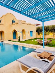 a villa with a swimming pool and a house at شمس تونس in Tunis