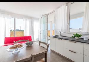 a kitchen with a wooden table and a red couch at White house in Avola