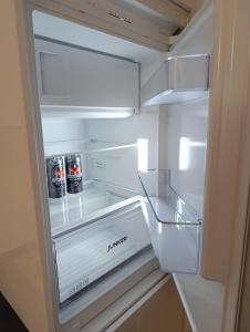 an open refrigerator with two cans of soda in it at Ferienwohnung Mergel in Black Forest in Zell im Wiesental