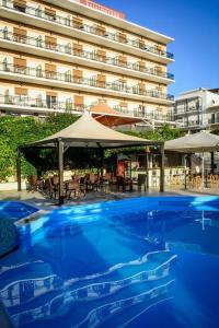 ein großes Schwimmbecken vor einem Gebäude in der Unterkunft Merope Hotel in Karlovasi