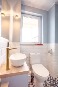 a bathroom with a white toilet and a window at Apartament Nadmorski in Ustka +9 photos