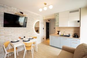 a kitchen and living room with a white table and chairs at Apartament Nadmorski in Ustka