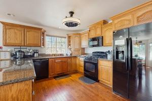 a kitchen with wooden cabinets and a black refrigerator at Life on Mt Olympia in South Lake Tahoe