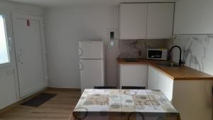 a kitchen with white cabinets and a white refrigerator at Casa MENDEZ 2 Allariz in Allariz