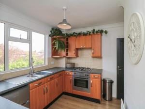 a kitchen with wooden cabinets and a sink at Top-Notch Flat in Saltburn-by-the-Sea