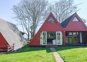 een klein rood huis met een groot raam bij Chalet Eighteen in Deal