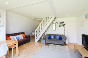 een woonkamer met twee banken en een trap bij Chalet Eighteen in Deal