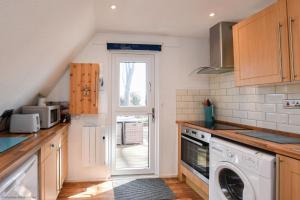 een keuken met een wasmachine en een deur naar een tuin bij Chalet Eighteen in Deal