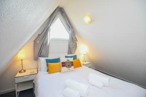 een slaapkamer met een wit bed en kleurrijke kussens bij Chalet Eighteen in Deal