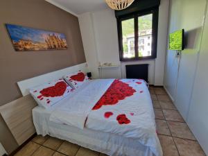 Un dormitorio con una cama con flores rojas. en BERNINA STATION CENTRE APARTMENT 1 - 30 seconds walk from bernina station, en Tirano
