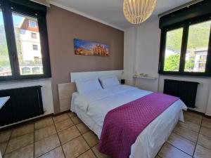 a bedroom with a bed with a purple blanket at Bernina Station Suite - 30 Steps to the Red Train in Tirano