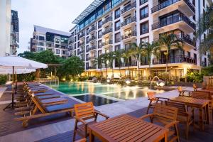 
a patio area with tables, chairs and umbrellas at Amanta Hotel & Residence Ratchada in Bangkok
