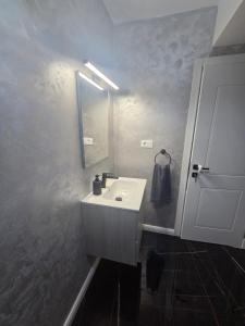 a bathroom with a white sink and a mirror at Studio Magheru Residence in Craiova