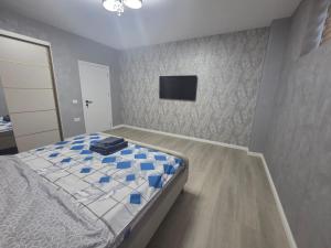 a bedroom with a bed and a tv on the wall at Studio Magheru Residence in Craiova