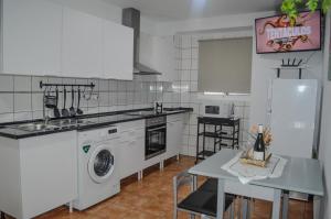 a kitchen with a washing machine and a table at Vv isla Verde in Mazo