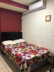 a bedroom with a bed with a floral blanket at Comfort Home Escalón in San Salvador +32 photos