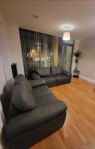 een woonkamer met een zwarte bank in de woonkamer bij 2 Bedroom Apartment - Henry St Central Liverpool in Liverpool