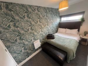 een slaapkamer met een bed met groen en wit behang bij 2 Bedroom Apartment - Henry St Central Liverpool in Liverpool +16 foto's