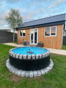 a small pool in front of a tiny house at The Garden Room in Spittal