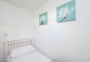 een slaapkamer met 2 foto's aan de muur en een bed bij Chalet Fortyfive in Deal