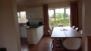 - une cuisine avec une table, une table et des chaises dans l'établissement Dungloe House, à Dungloe 8 autres photos