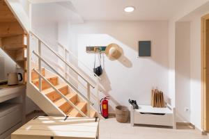 a staircase in a home with white walls and wooden stairs at Nikkon summer home in Matala
