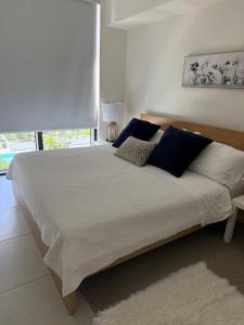 a bedroom with a large bed with blue pillows at Down Town Doral 1b in Miami +19 photos
