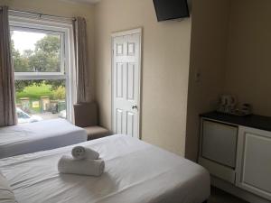 a hotel room with two beds and a window at Spindrift Guest house in Great Yarmouth