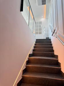 a staircase with brown treads and a white wall at Villa Maréa in Algeciras