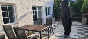 a patio with a wooden table and an umbrella at Strandhygge in Flensburg