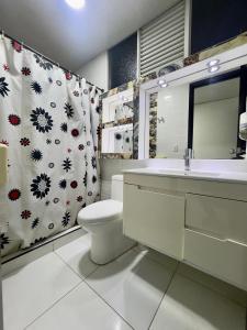 Un baño con inodoro, lavabo y cortina de ducha. en Hotel Blue, en Santa Rosa de Cabal