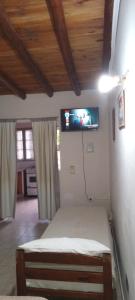 a bedroom with a bed with a tv on the wall at Monoambiente Blanca in Concordia