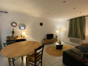 a living room with a table and a couch at Gîte avec spa in Saint-Avit-Sénieur