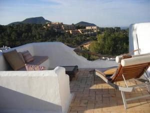 a patio with a couch and chairs on a roof at Na Sabina in Cala Vadella