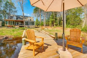 2 chaises et un parasol sur une terrasse en bois dans l'établissement Dock, Sunrooms and Fire Pits Deltaville Home!, à Deltaville