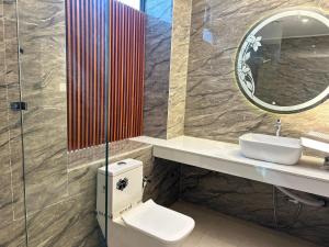 a bathroom with a toilet and a sink and a mirror at Hotels7Apple in Mahoba