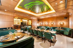 a dining room with tables and green chairs at Ultimate Elegance Studio with Panoramic City Views in Miami