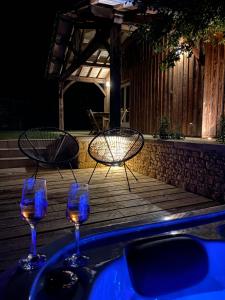 two wine glasses and a light on a table at Gîte avec spa in Saint-Avit-Sénieur