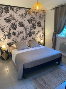 a bedroom with a bed with a black and white wallpaper at Gîte avec spa in Saint-Avit-Sénieur