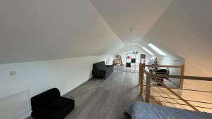 Habitación en el ático con 2 sillas y 1 cama en Le confort contemporain dans un écrin de verdure, en Vernon