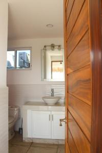 a bathroom with a sink and a wooden door at Penthouse vistamar puerto escondido in Puerto Escondido +21 photos